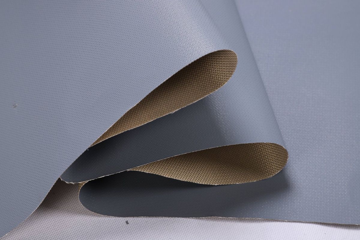 Grey PTFE-coated fiberglass folded to show the smooth grey face and the tan woven reverse